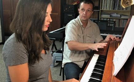Teacher and student at the piano during a lesson